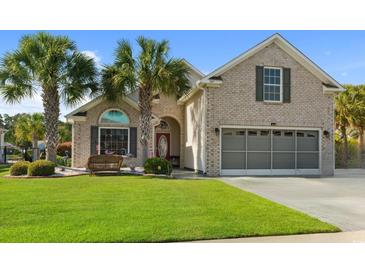 Charming brick home featuring a well-maintained lawn, palm trees, and a two-car garage at 347 Kessinger Dr., Surfside Beach, SC 29575