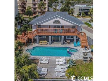 Stunning backyard featuring a pool, spa, sundeck, lounge chairs, and outdoor seating area at 4501 S Ocean Blvd., North Myrtle Beach, SC 29582