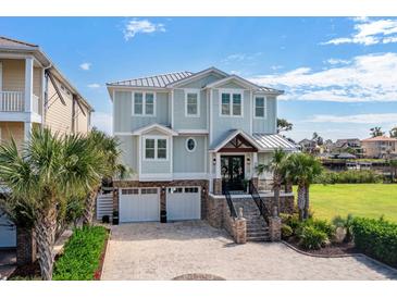 Stunning two-story home featuring a meticulous brick driveway, two-car garage, and beautiful landscaping, including mature palm trees at 4832 Williams Island Dr., Little River, SC 29566