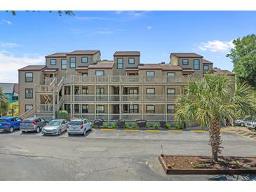 Three-story condo building with wooden balconies, parking, and a well-maintained landscape at 501 Maison Dr. # G-7, Myrtle Beach, SC 29572