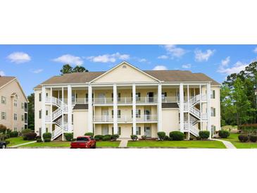 Inviting three-story condo building with multiple balconies, white railings, and exterior staircases at 5840 Longwood Dr. # 303, Murrells Inlet, SC 29576