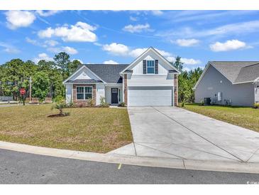 Charming one-story home with white siding, stone accents, and a spacious two-car garage with long driveway at 914 Padgett Lane, Conway, SC 29526