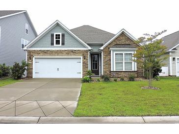 Charming home featuring stone accents, a two-car garage, and a beautifully manicured front yard at 932 Mildred Ct., Murrells Inlet, SC 29576