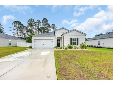 Charming single-story home features a manicured lawn and attached garage at 112 Carolina Lakes Blvd., Myrtle Beach, SC 29588