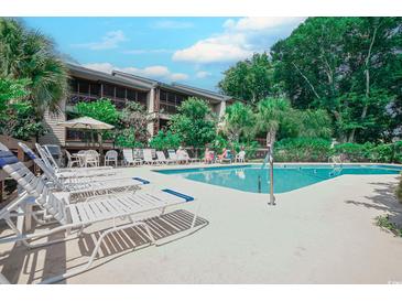 Inviting community pool area with ample lounge chairs and lush landscaping at this condo community at 223 Maisons Dr. # C8, Myrtle Beach, SC 29572