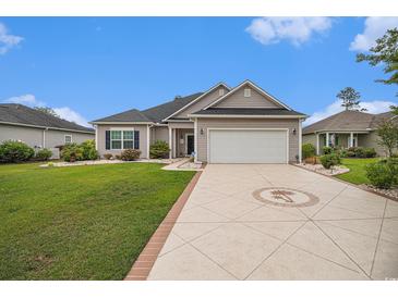 Charming single-story home featuring a well-manicured lawn and patterned driveway leading to a two-car garage at 325 Galway Ct., Longs, SC 29568