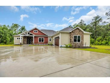 Beautiful home with a two-car garage and a combination of tan siding and red brick features at 3995 Tillmond Dr., Conway, SC 29526