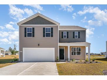 Charming two-story home with a well-maintained front yard and attached two car garage at 406 Glade Ct., Loris, SC 29569