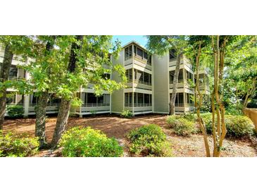 Beautiful three-story condo building with screened-in porches, surrounded by trees and lush landscaping at 415 Ocean Creek Dr. # 2161, Myrtle Beach, SC 29572