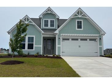 Charming coastal-style home featuring a two-car garage and light-blue shingles with clean landscaping at 732 St. Vincent Loop, Little River, SC 29566