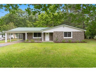 Charming stone and siding home featuring a green metal roof, well-kept lawn, and an attached carport at 96 Middleton Rd., Andrews, SC 29510