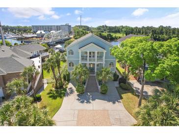 Stunning two-story home with a grand entrance, lush landscaping, and a beautiful view of the waterway and bridge at 107 Waterway Crossing Ct., Little River, SC 29566