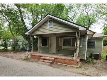 Modest home with olive green siding, a small front porch, and a brick stairway at 1744 John St., Conway, SC 29527