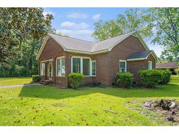 Charming brick home featuring large windows and a well-maintained lawn, perfect for suburban living at 1895 Bucksville Dr., Conway, SC 29527