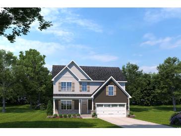 Charming two-story home with gray and brown siding, complemented by a well-manicured lawn and a two car garage at 2222 Hazel Way, Longs, SC 29568
