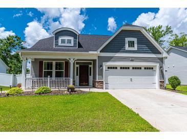 Charming two-story home boasts a well-manicured lawn, front porch, and a two-car garage for ample parking at 395 Dunbarton Ln., Conway, SC 29526