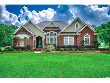 Charming brick home with a manicured lawn, lush landscaping, and great curb appeal at 4260 Long Avenue Ext., Conway, SC 29526