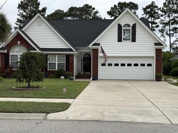 Charming home featuring brick accents, a well-manicured lawn, and a two-car garage at 4818 Harvest Dr., Myrtle Beach, SC 29579