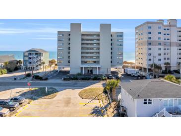 Exterior shot of a multi-story condominium building near the beach, with parking and landscaping at 5806 N Ocean Blvd. # 203, North Myrtle Beach, SC 29582