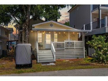 Charming yellow cottage with a welcoming front porch, string lights, and a cozy beach vibe at 6001 - 1820A S Kings Hwy., Myrtle Beach, SC 29575