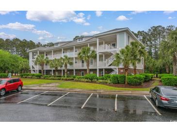 Three-story condo building with light siding, stairs, and palm trees at 6253 Catalina Dr. # 433, North Myrtle Beach, SC 29582