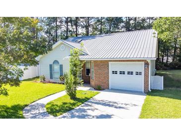 Charming single-story home featuring a brick facade, metal roof, and well-manicured lawn at 9664 Middleton Ct., Murrells Inlet, SC 29576
