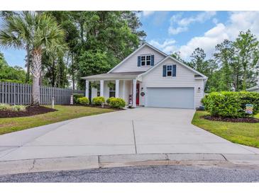 Charming single Gathering home featuring a well-manicured lawn, attached garage, and eye-catching red front door at 1009 Oak Marsh Ln., North Myrtle Beach, SC 29582