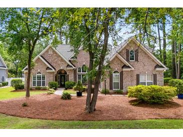 Charming brick home featuring mature trees, manicured landscaping, and an inviting front entrance at 1315 Cherry Dr., Surfside Beach, SC 29575