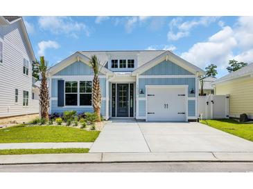 Charming single-Gathering home with blue siding, landscaping, and a one-car garage at 1533 Coastal Cove Ln, Calabash, NC 28467