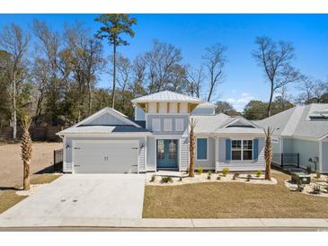 Charming coastal home featuring a two-car garage and beautifully landscaped front yard at 1946 Indigo Cove Ln, Calabash, NC 28467