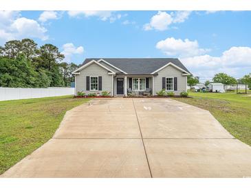 Charming single-story home featuring a well-manicured lawn, long driveway, and inviting front porch at 2521 Wise Rd., Conway, SC 29526