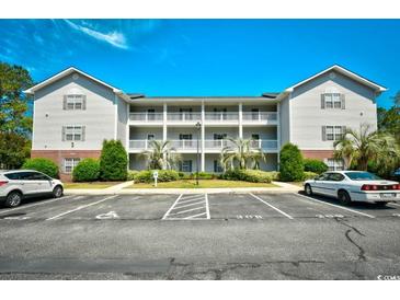 Exterior shot of a three-story condo building with white balconies and well-maintained landscaping at 4811 Innisbrook Ct. # 306, Myrtle Beach, SC 29579