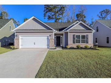 Charming single-story home featuring a two-car garage and a well-manicured lawn, under a clear blue sky at 608 Woodside Dr., Conway, SC 29526