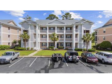 Well-maintained condo building featuring multiple levels, a parking lot, and palm trees at 633 Waterway Village Blvd # 11D, Myrtle Beach, SC 29579