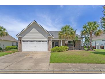 Charming single-story home with a well-manicured lawn and attached two-car garage at 691 Sandberg St., Surfside Beach, SC 29575