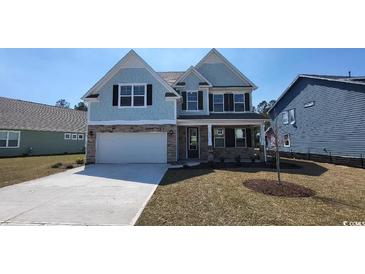 Charming two-story home with stone accents, blue siding, a front lawn, and an attached two-car garage at 756 Choctaw Dr., Conway, SC 29526