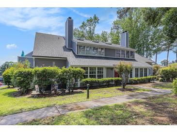 Charming two-story home with mature landscaping, gray siding, and a well-maintained front yard at 1206 Erin Way # A, Myrtle Beach, SC 29577