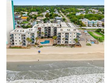 Aerial shot highlighting the building's beachfront location, pool, and ocean views at 1310 N Waccamaw Dr. # 204, Garden City Beach, SC 29576