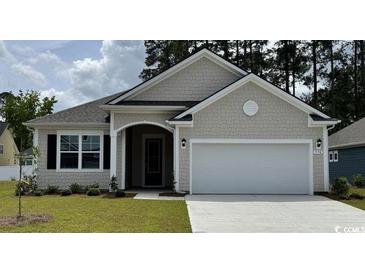 Charming single-story home with a two-car garage and well-manicured lawn, showcasing curb appeal at 157 Stride Ct., Myrtle Beach, SC 29588
