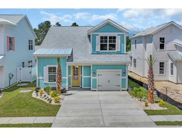 Charming light-blue two-story home with a welcoming yellow door and well-maintained landscaping at 1961 Indigo Cove Ln, Calabash, NC 28467