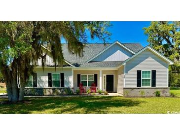 Charming single-story home with light gray siding, black shutters, well-maintained lawn, and a welcoming front porch at 206 N Levee Dr., Georgetown, SC 29440