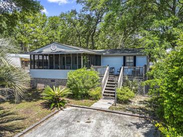 Quaint home with an inviting porch, steps, and established greenery, offering charm and curb appeal at 2425 Park St., North Myrtle Beach, SC 29582