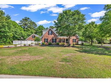 Charming brick home featuring a well-manicured lawn and mature trees offering great curb appeal at 2441 Hunters Trail, Myrtle Beach, SC 29588