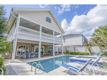Inviting backyard featuring a sparkling pool, lounge chairs, and covered patio, perfect for outdoor relaxation at 500 23Rd Ave. S, North Myrtle Beach, SC 29582