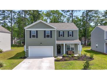 Charming two-story home featuring a welcoming front porch, manicured lawn, and attached two-car garage at 1020 Sennema Circle, Myrtle Beach, SC 29588