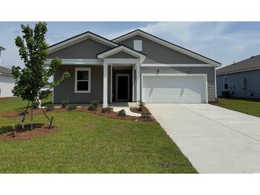 Charming one-story home with gray siding, well-manicured lawn, and attached two-car garage at 1034 Laconic Dr., Myrtle Beach, SC 29588