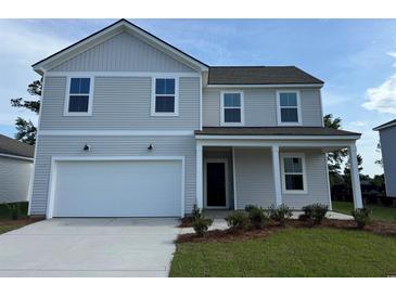 Charming two-story home with neutral siding, a front-entry two-car garage, and a well-manicured lawn at 1035 Laconic Dr., Myrtle Beach, SC 29588