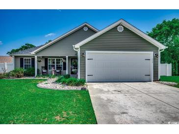 Charming single-story home with a well-manicured lawn, inviting front porch, and attached two car garage at 113 Adelphia Rd., Loris, SC 29569