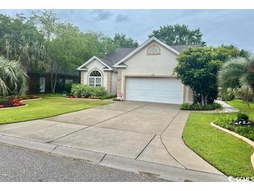 Charming single-story home with a well-manicured lawn, mature landscaping, and a two-car garage at 1504 Saint Thomas Circle, Myrtle Beach, SC 29577