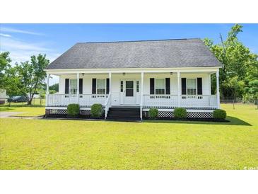 Charming single-story home featuring a welcoming front porch and well-manicured lawn at 1763 Lipscomb Rd., Mullins, SC 29574